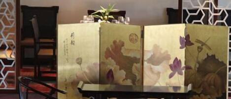 A traditional Japanese room with tatami flooring, a low table, and a shoji screen with floral artwork.