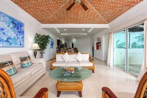 A spacious living room with a sofa, a coffee table, and a dining area in the background. - Aventuras Club Lagoon (Puerto Aventuras)