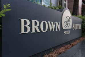 A sign for Brown Suites in Seoul, featuring a modern design with the hotel's name and logo. - Brown Suites Seoul (Seoul)