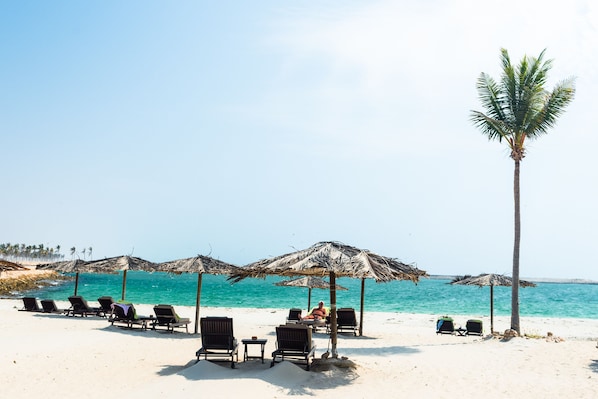Am Strand, Liegestühle, Sonnenschirme, Strandtücher