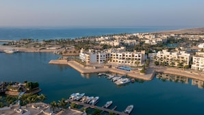 A coastal town with a marina, buildings, and a beach.