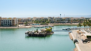 A resort with a marina, palm trees, and a clear view of the water.
