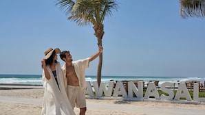 A beach scene with a sign reading "HAWANASAI" and palm trees.