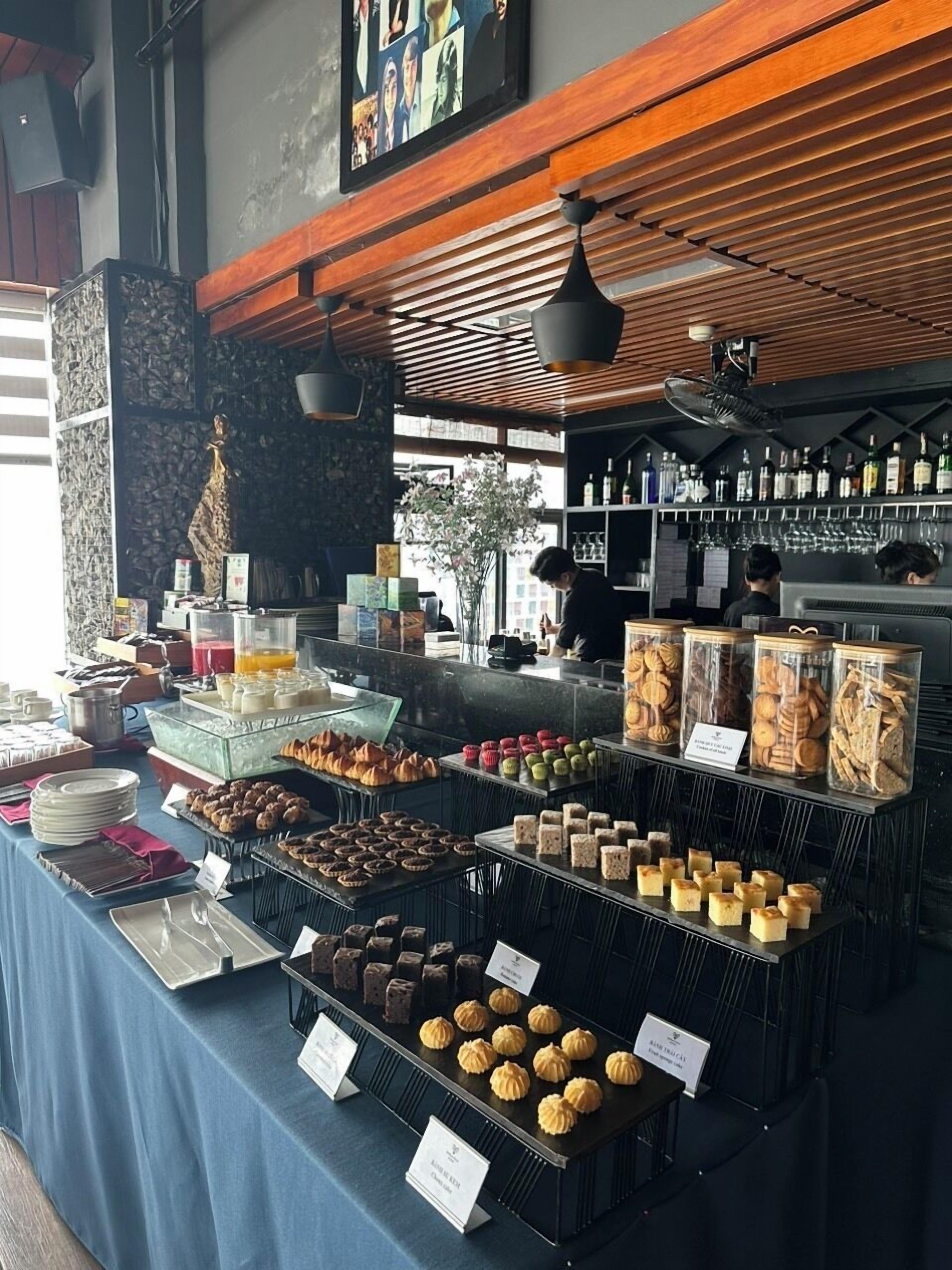 A buffet with various food items and a bar area with bottles and glasses.