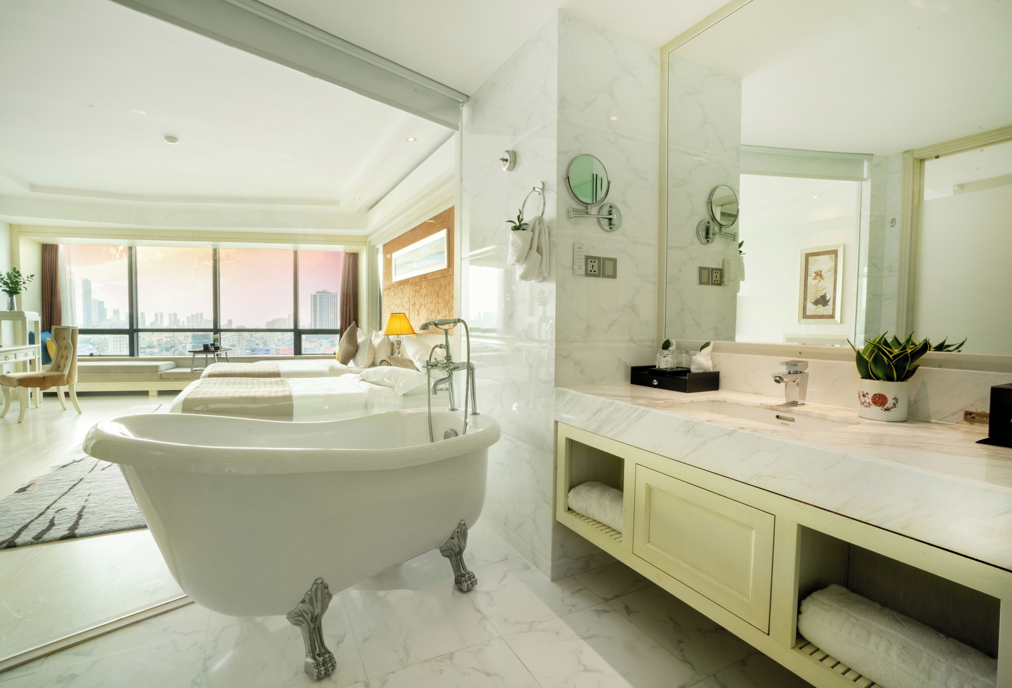 Un baño moderno con una bañera independiente, un espejo grande y un mueble de tocador con lavabo.