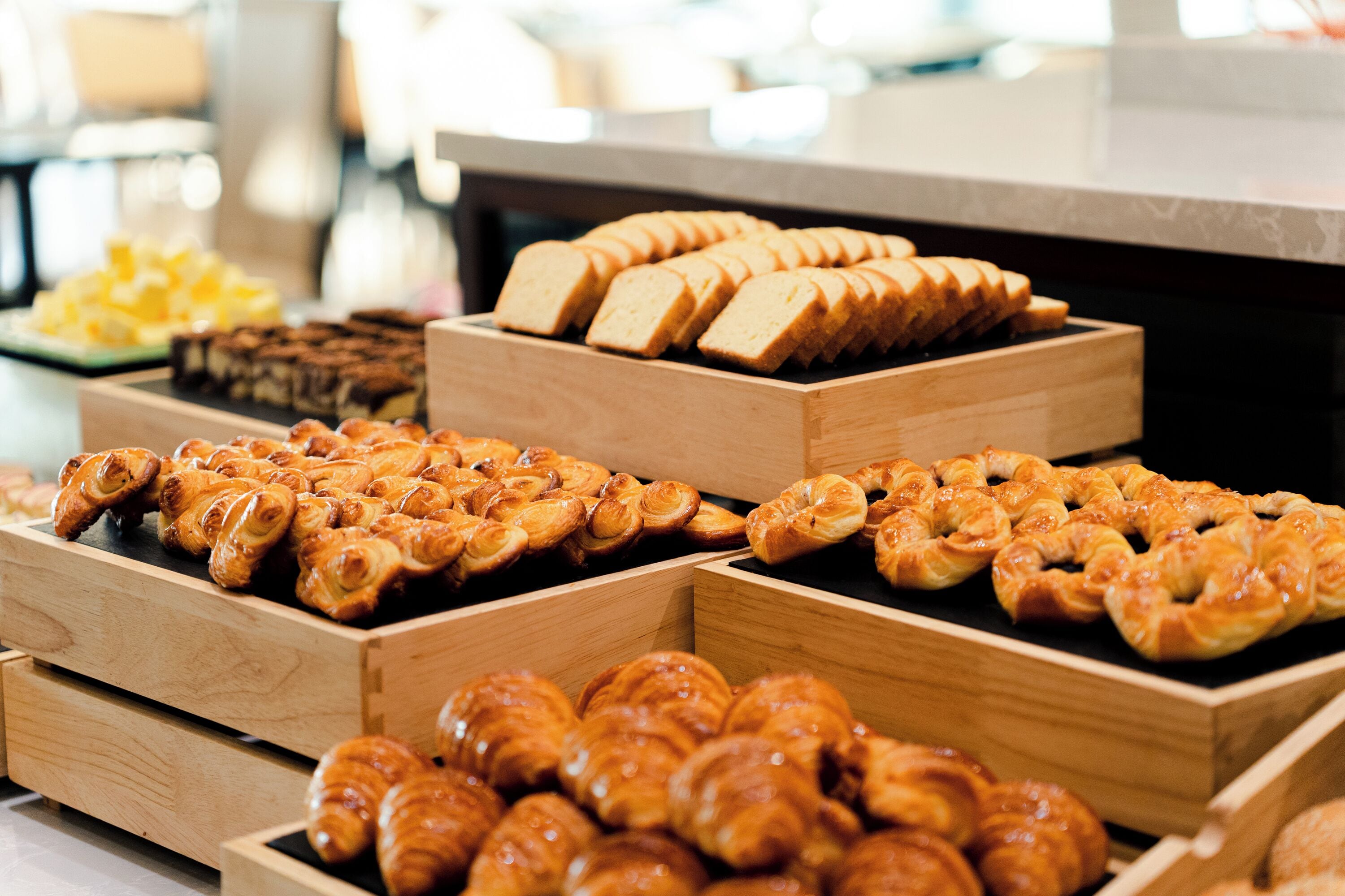 A display of various baked goods in wooden boxes.