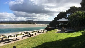 A beachside park with picnic tables and a gazebo overlooking the ocean.