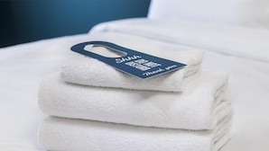 A stack of white towels with a tag that reads "Shhh DO NOT DISTURB Thank you." - Travelodge London Balham (London)