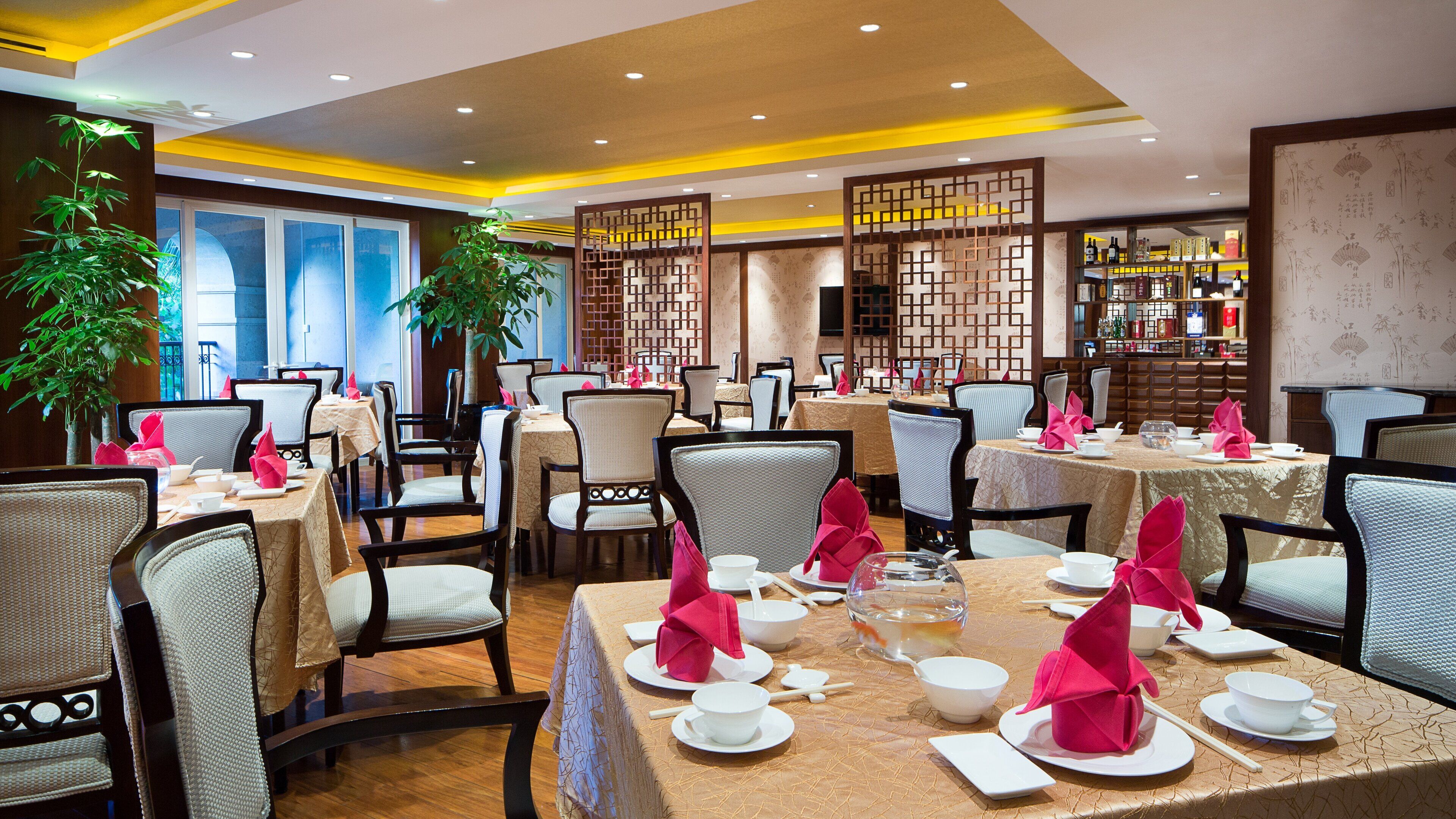 A restaurant with multiple tables set for dining, featuring traditional decor and a variety of seating arrangements.