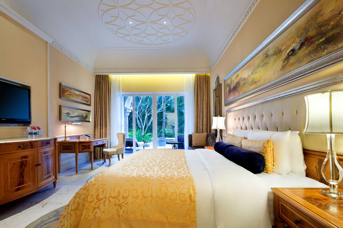 Une chambre d’hôtel avec un grand lit, un bureau, une télévision et une vue sur l’extérieur.