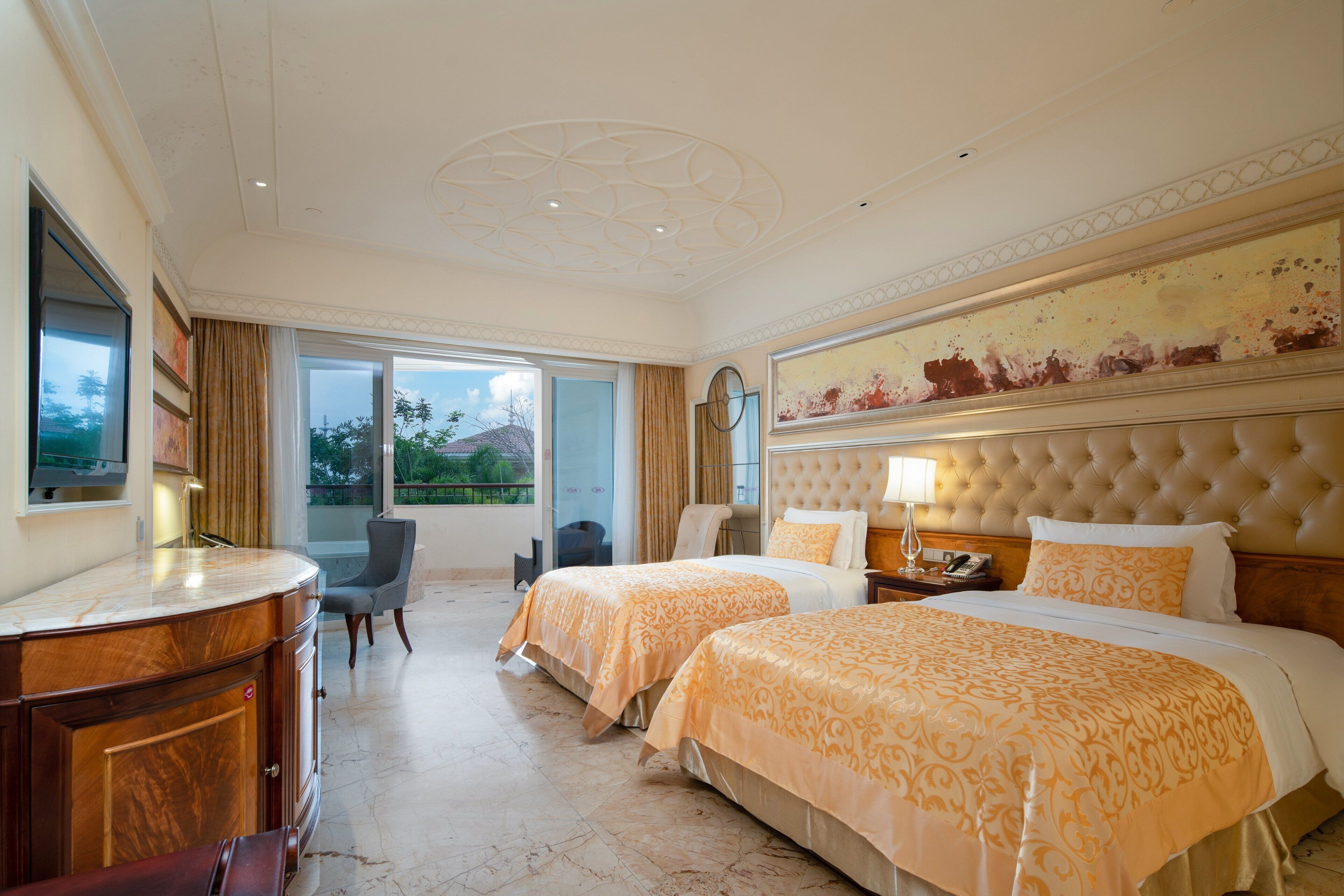 A hotel room with two beds, a sitting area, a large window, and a view of the outdoors.