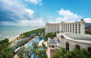 A resort with a large pool, beachfront, and a multi-story building with balconies.