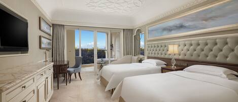Une chambre d’hôtel avec deux lits, une télévision, un bureau avec une chaise et un balcon avec vue.