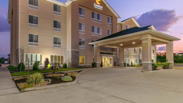 Un hotel Comfort Inn & Suites con un diseño moderno, que cuenta con una entrada cubierta y jardines ajardinados.