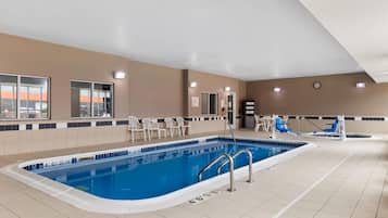 Una piscina techada, sillones reclinables de piscina