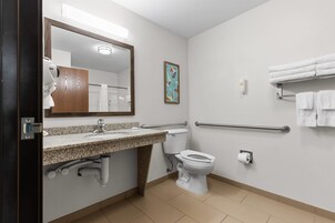 Un baño moderno con lavamanos de granito, inodoro, secador de manos, toallero y dispensador de gel antibacterial.