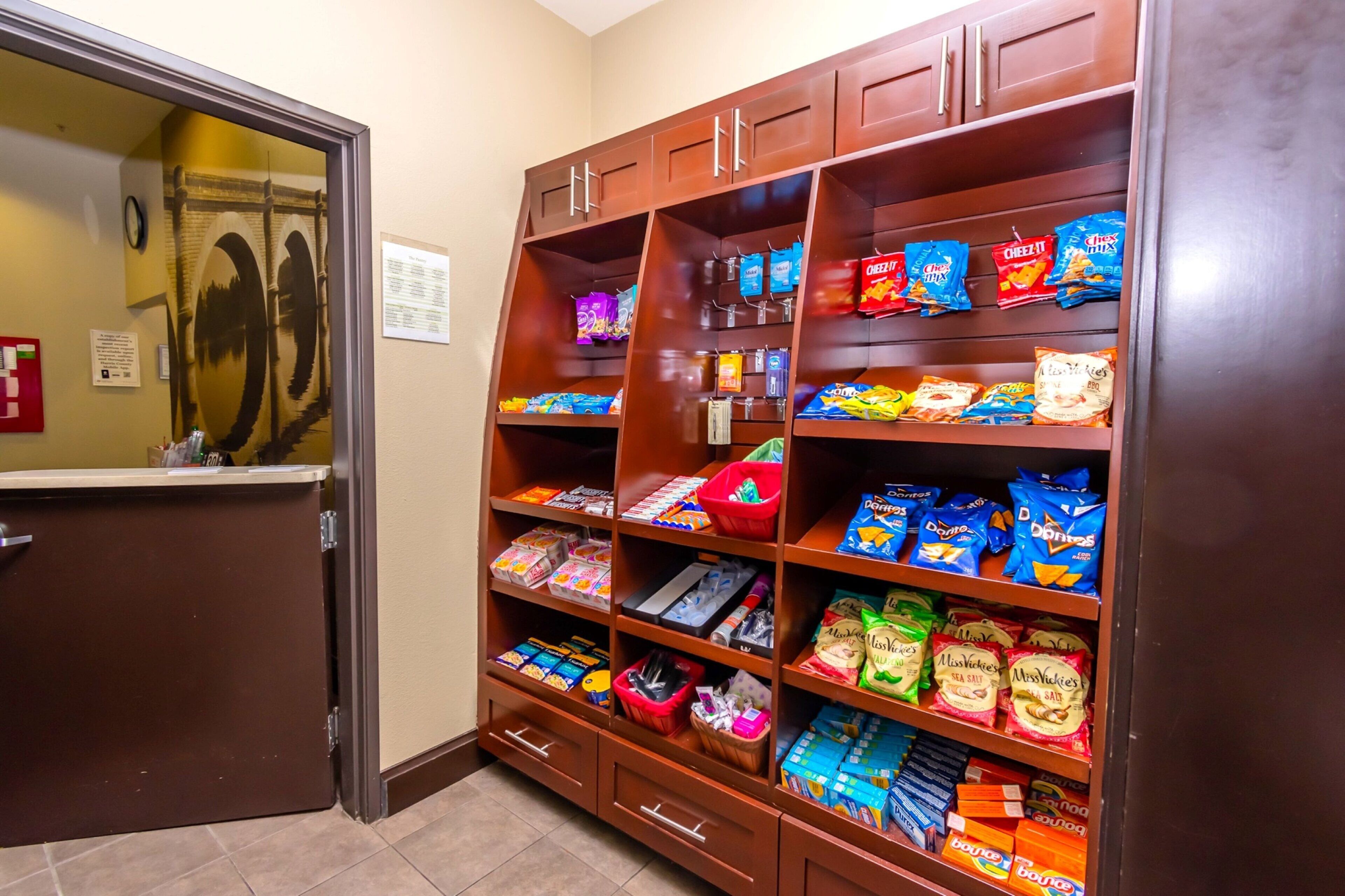 A snack vending area with various packaged snacks and a small trash bin.