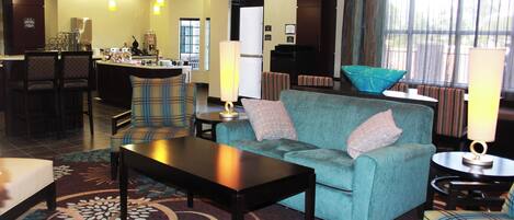 A hotel lobby with a bar area, seating, and a reception desk.