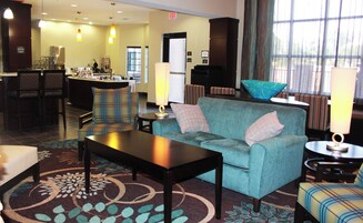 A hotel lobby with a bar area, seating, and a reception desk.