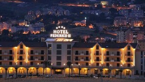 Un hotel de varios pisos, con un letrero llamativo y una serie de balcones.