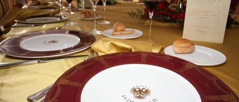 A formal dining table set with plates, glasses, and cutlery, indicating a restaurant or dining area.