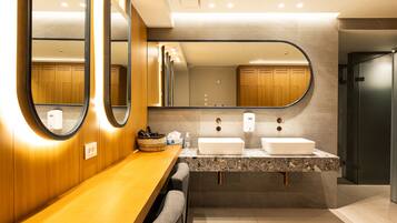 Un baño moderno con dos lavamanos, un espejo grande y muebles de madera.