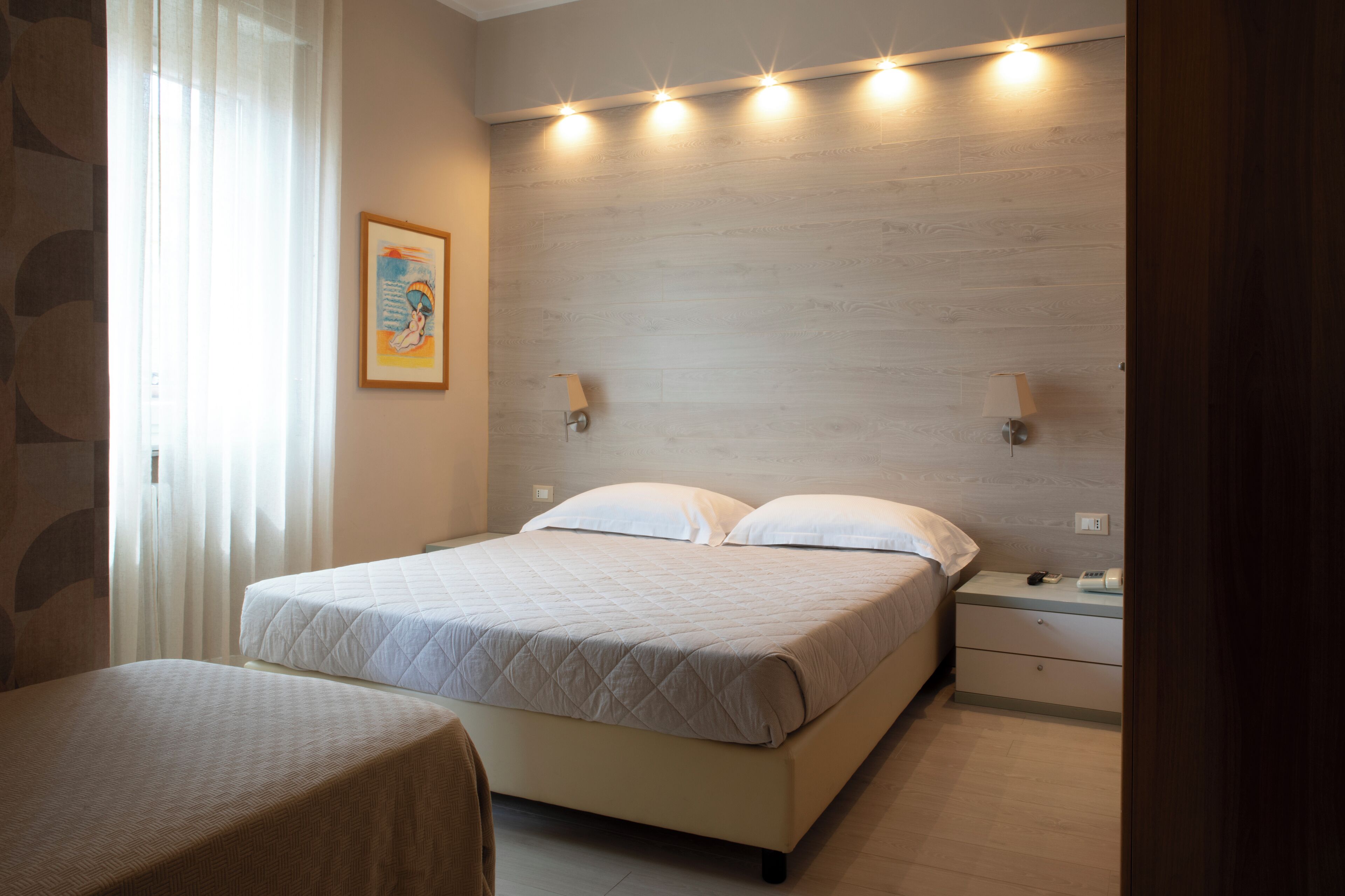 A bedroom with a bed, bedside tables, and a nightstand.