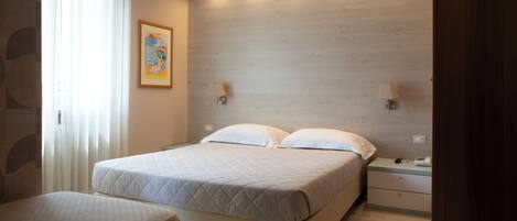 A bedroom with a bed, bedside tables, and a nightstand.