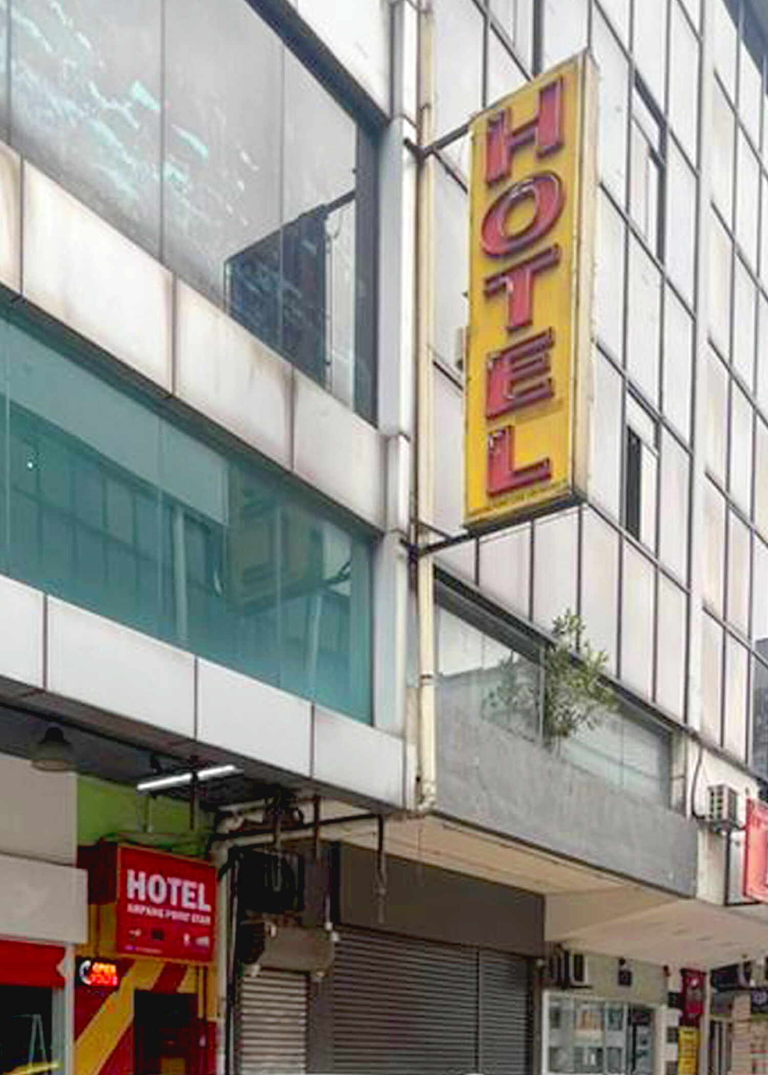 A hotel building with a prominent yellow sign indicating its presence.