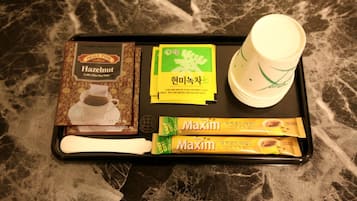 Una bandeja con un filtro para café, una taza de café y dos sobres de café instantáneo Maxim.