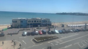 Un edificio frente al mar con estacionamiento y vistas al océano.