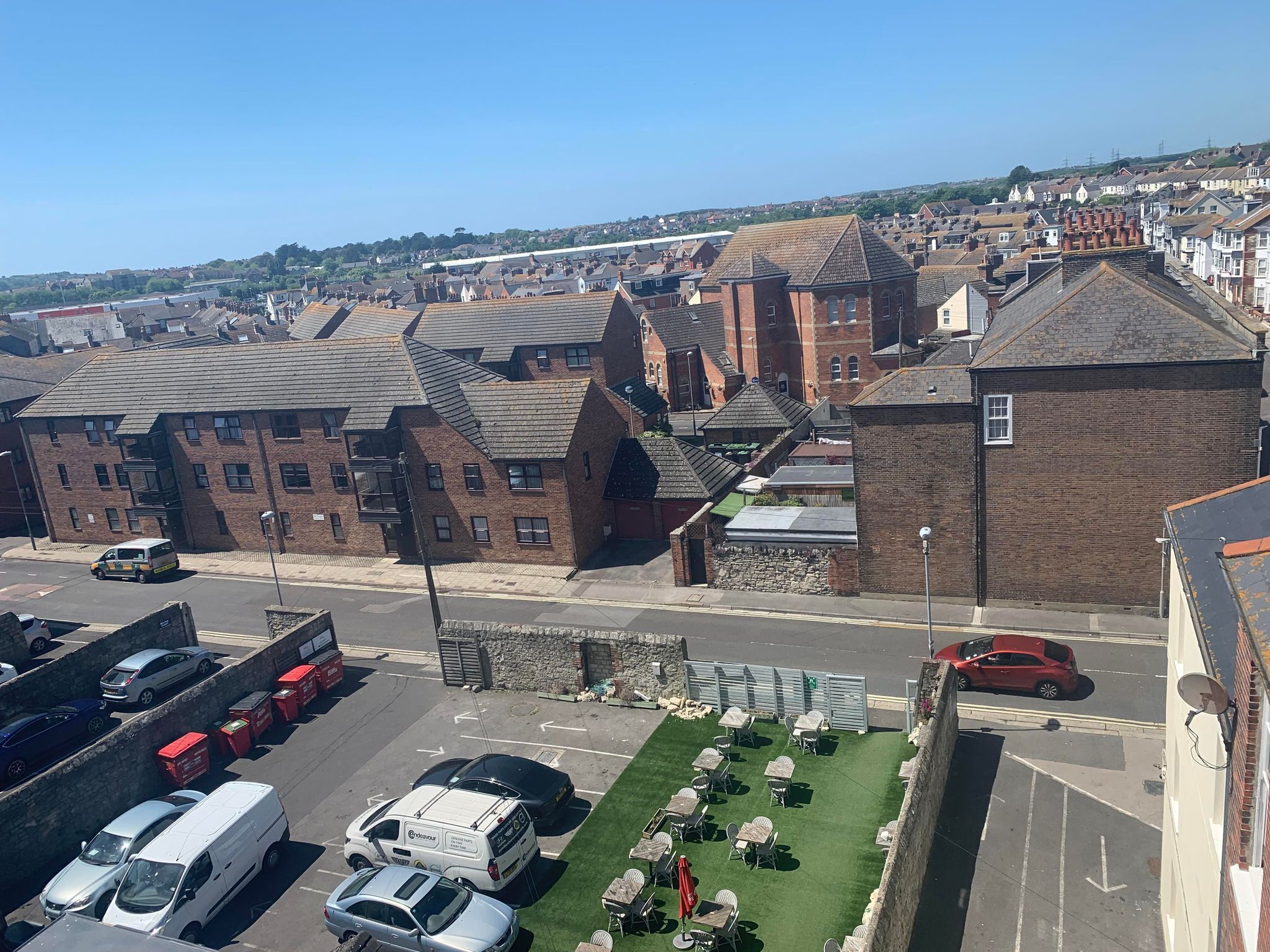 A parking area with several cars and a white van.