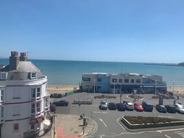 Vista costera con un área de estacionamiento, edificios y playa.