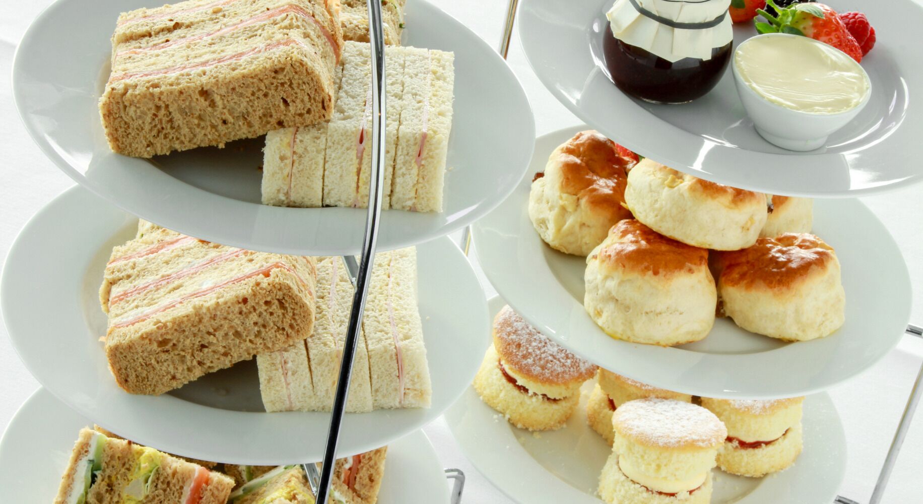 Een drijbaar plateau met diverse sandwiches en scones.