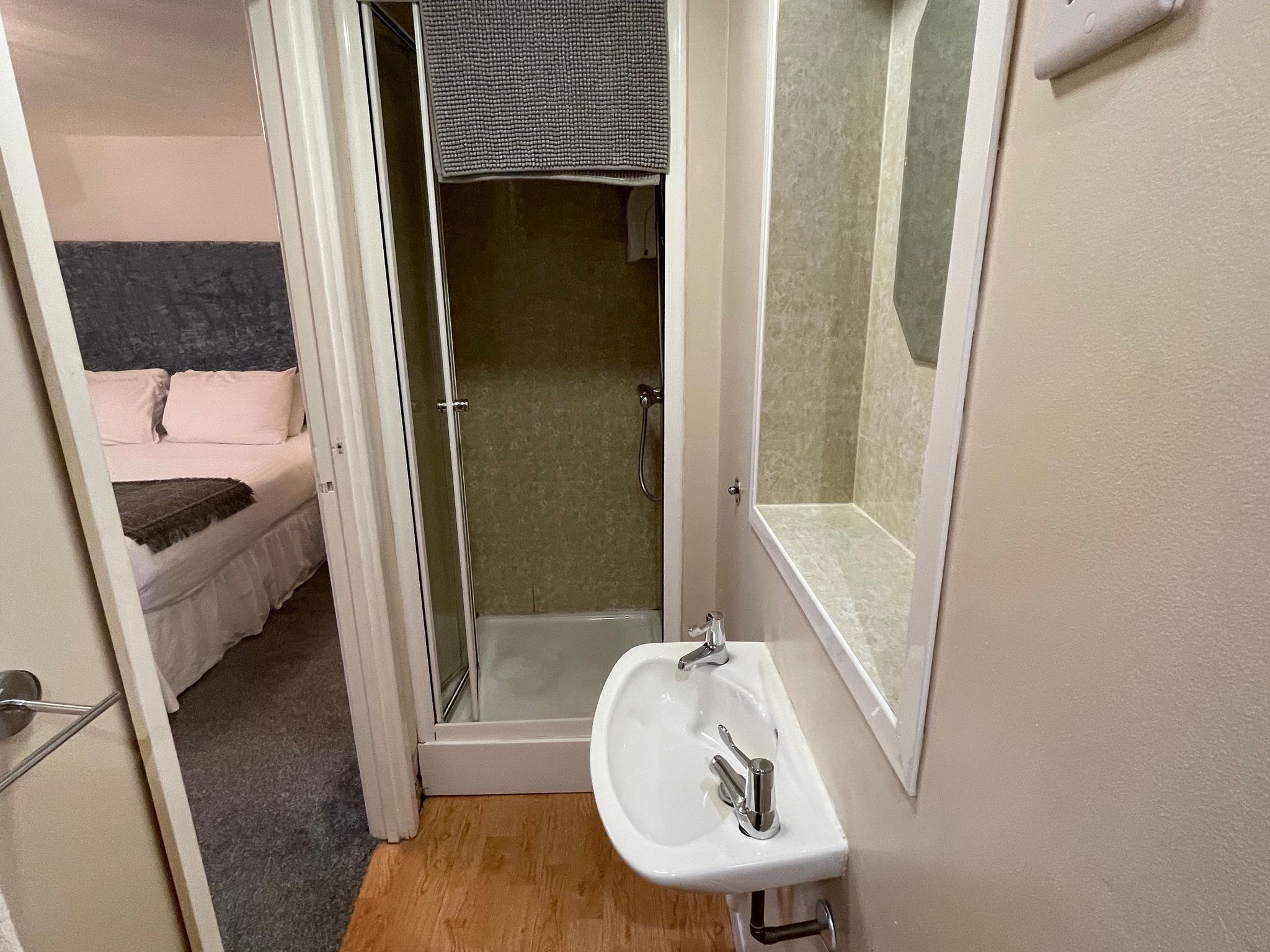 A bathroom with a shower, a sink, and a mirror.