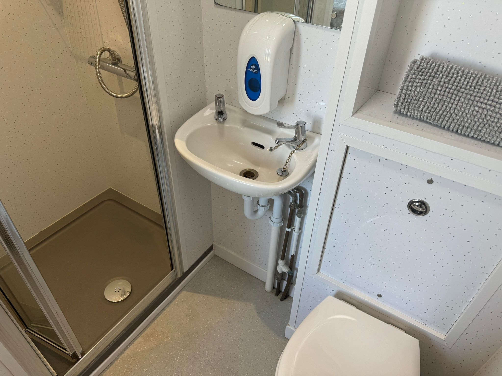 A bathroom with a shower, sink, and toilet.