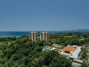 A coastal resort with two high-rise buildings, lush greenery, and a clear view of the sea. - The Atta Terrace Club Towers (Onna)