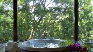 A hot tub with a view of a forest through a large window. - The Atta Terrace Club Towers (Onna)