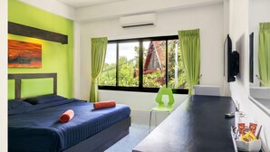 A hotel room with a bed, a desk, a chair, and a window with curtains. - Art Hotel Chaweng Beach (Koh Samui)