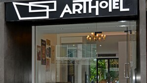 The exterior of the Arthotel with a modern design, featuring a glass entrance and a visible interior through the glass. - Art Hotel Chaweng Beach (Koh Samui)