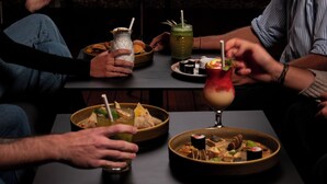 A table with various dishes and drinks, including sushi and a cocktail with a fruit garnish. - Chateau Royal Beach Resort and Spa (Nouméa)