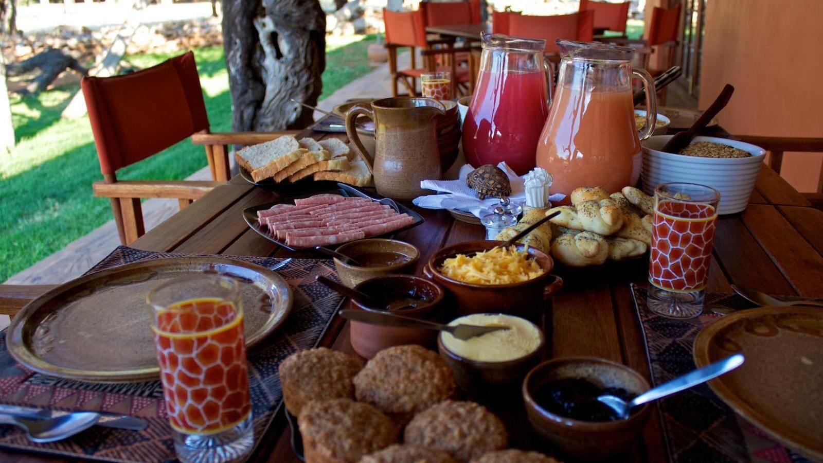 A breakfast table with various food items, including bread, eggs, and beverages.