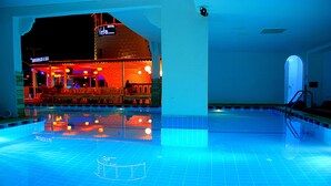 Una piscina con una zona de bar adyacente.