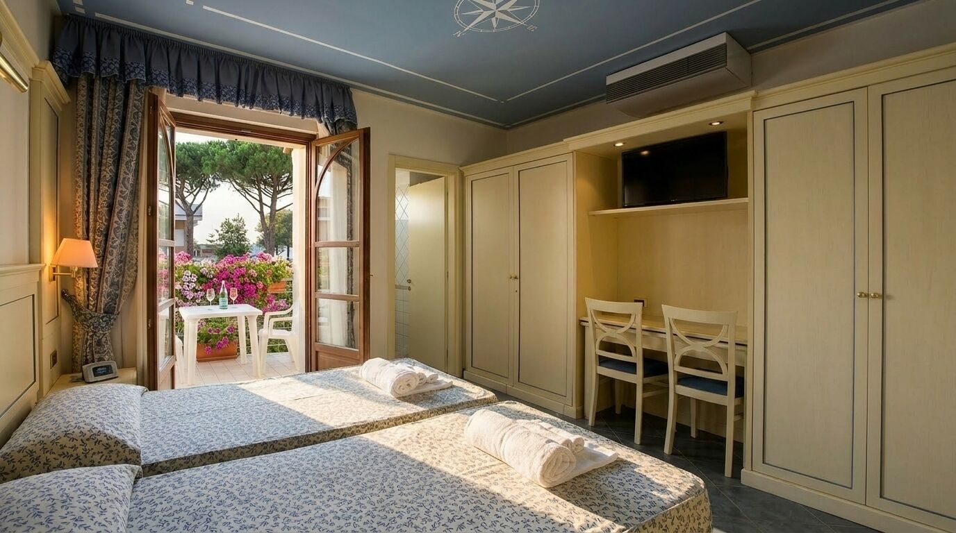 A bedroom with a bed, a desk, and a wardrobe. There is a window with curtains and a view of a garden.