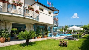 Un hotel con piscina, mobiliario exterior y vistas a las montañas.