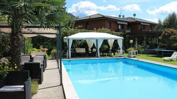 Piscine extérieure, parasols de plage, chaises longues