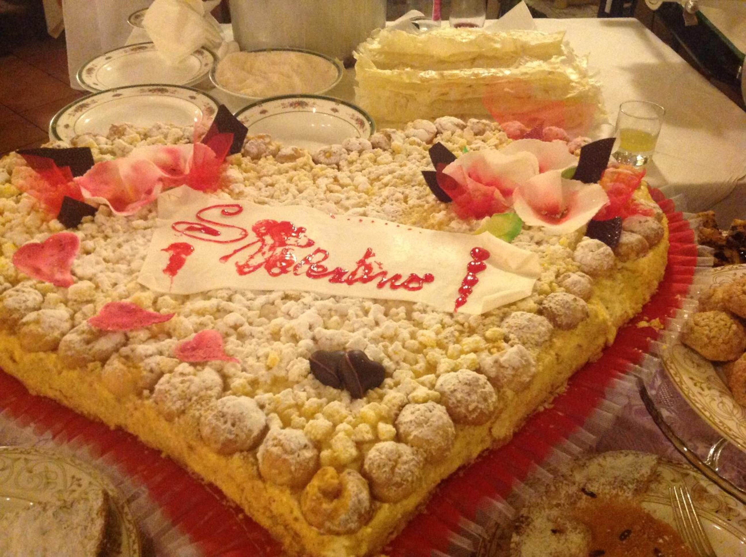 A heart-shaped cake with decorative elements and a sign that reads "St. Valentine."