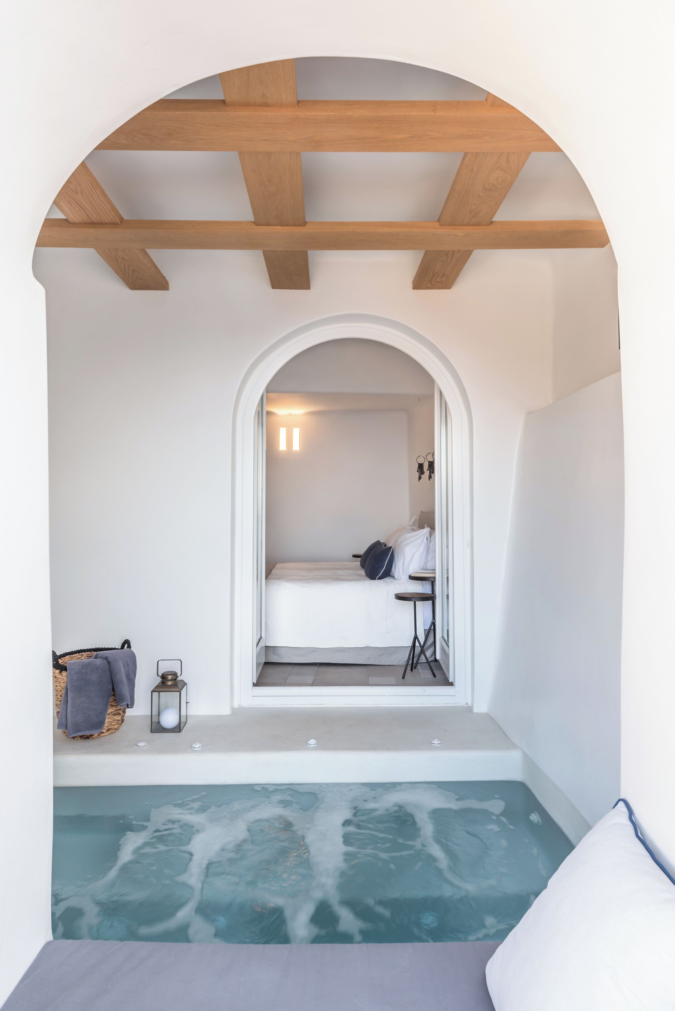 A spa room with a bathtub, a bed, and a small table.
