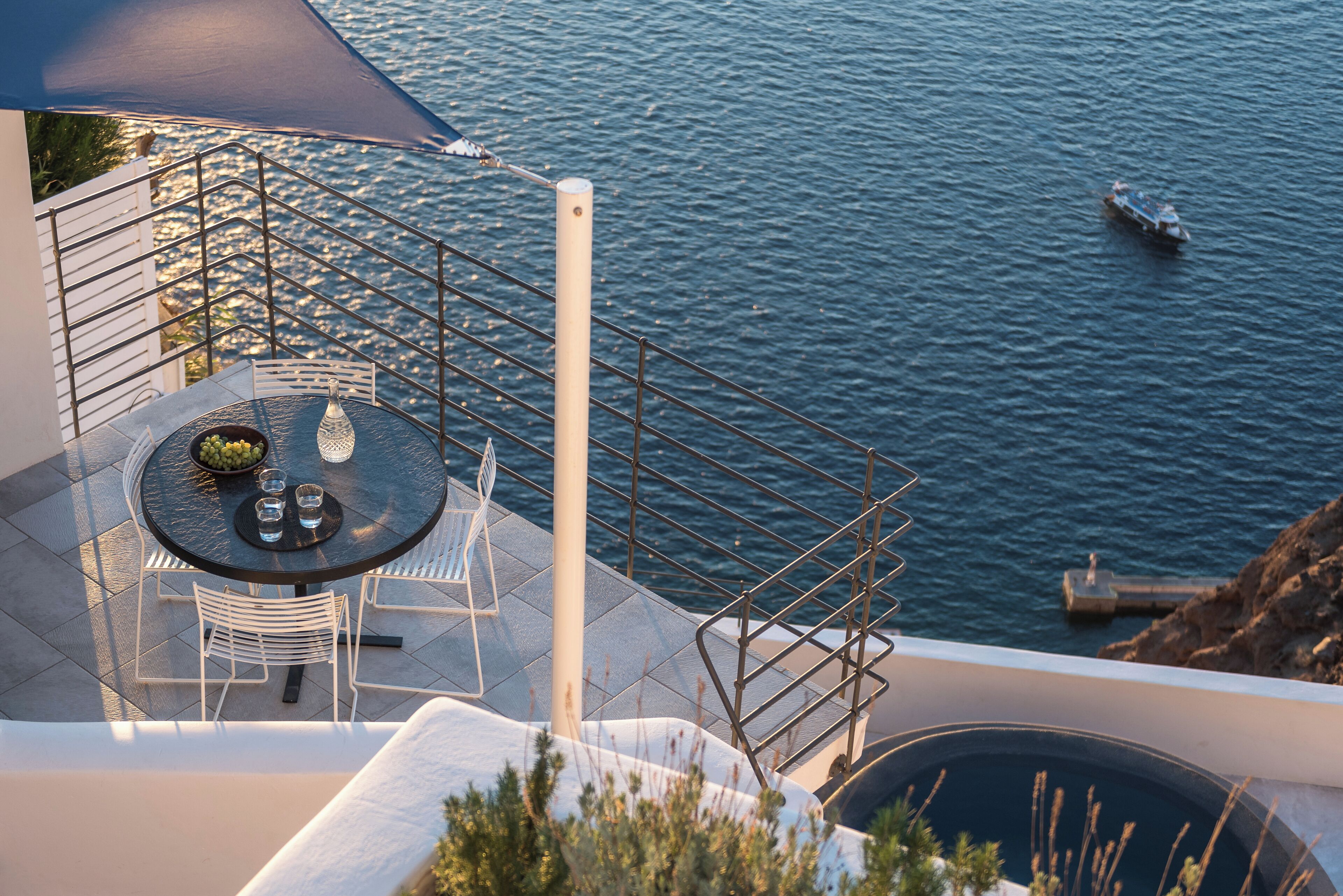 Eine Terrasse mit Tisch und Stühlen mit Blick auf ein Gewässer.