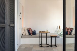 A modern interior with a sofa, two round tables, and decorative items.